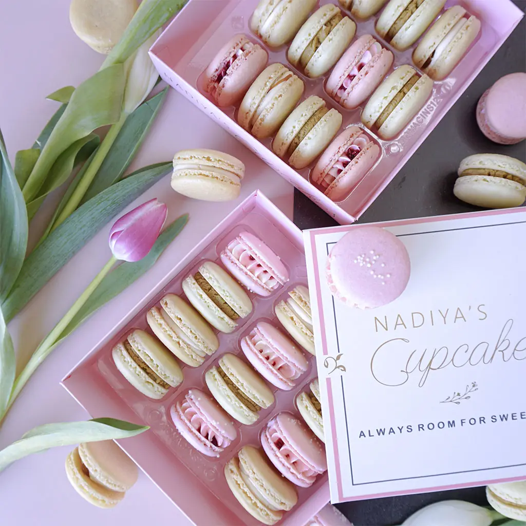 Two boxes of macarons with tulips around them, by Nadiya's Cupcakes