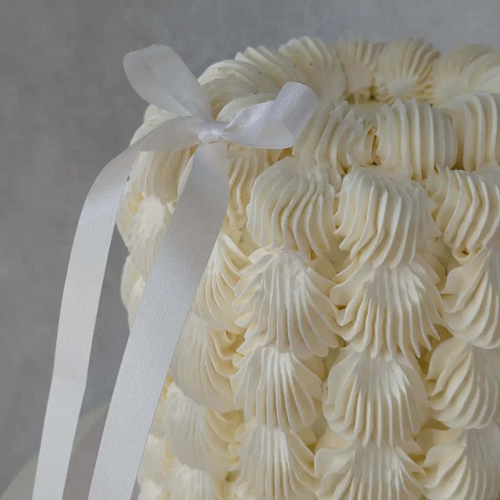 Top close-up of white buttercream cake with thick dotted buttercream dots all round on cake stand, by Nadiya's Cupcakes